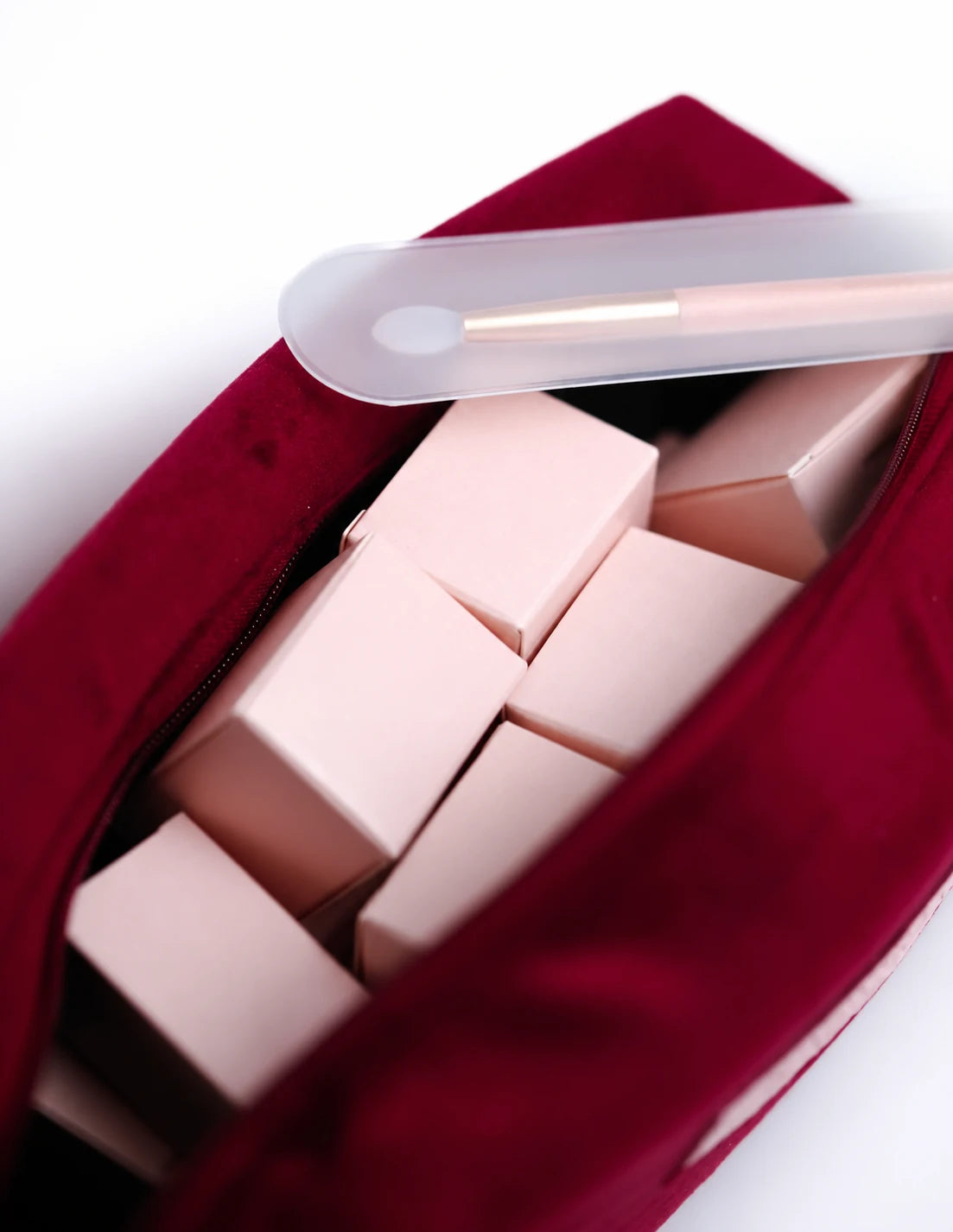 Open burgundy collection bag with boxed pigments