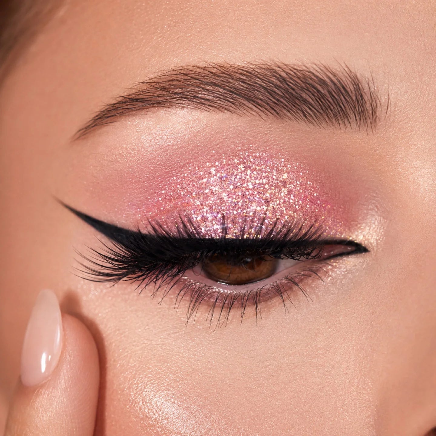 Close-up of pink shimmer eyeshadow with winged liner and a clean under-eye finish