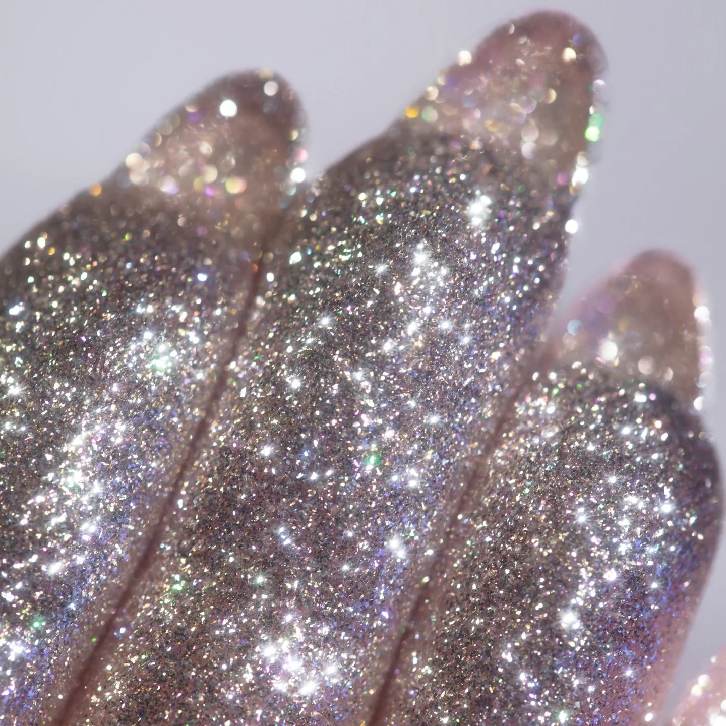 Silver shimmer pigment on fingertips, showing the reflective texture close up